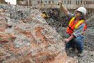 Archeologist Martin Royer takes measurements next to the foundations and the lower walls of the old gas reservoir on the corner of Ottawa and Ann Sts. last week. Photograph by: Pierre Obendrauf , The Gazette