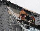 An Empire Restoration crew removes original roofing material from the south side lower level of the city hall roof in preparation for the installation of new metal panels - REG CLAYTON, Miner and News